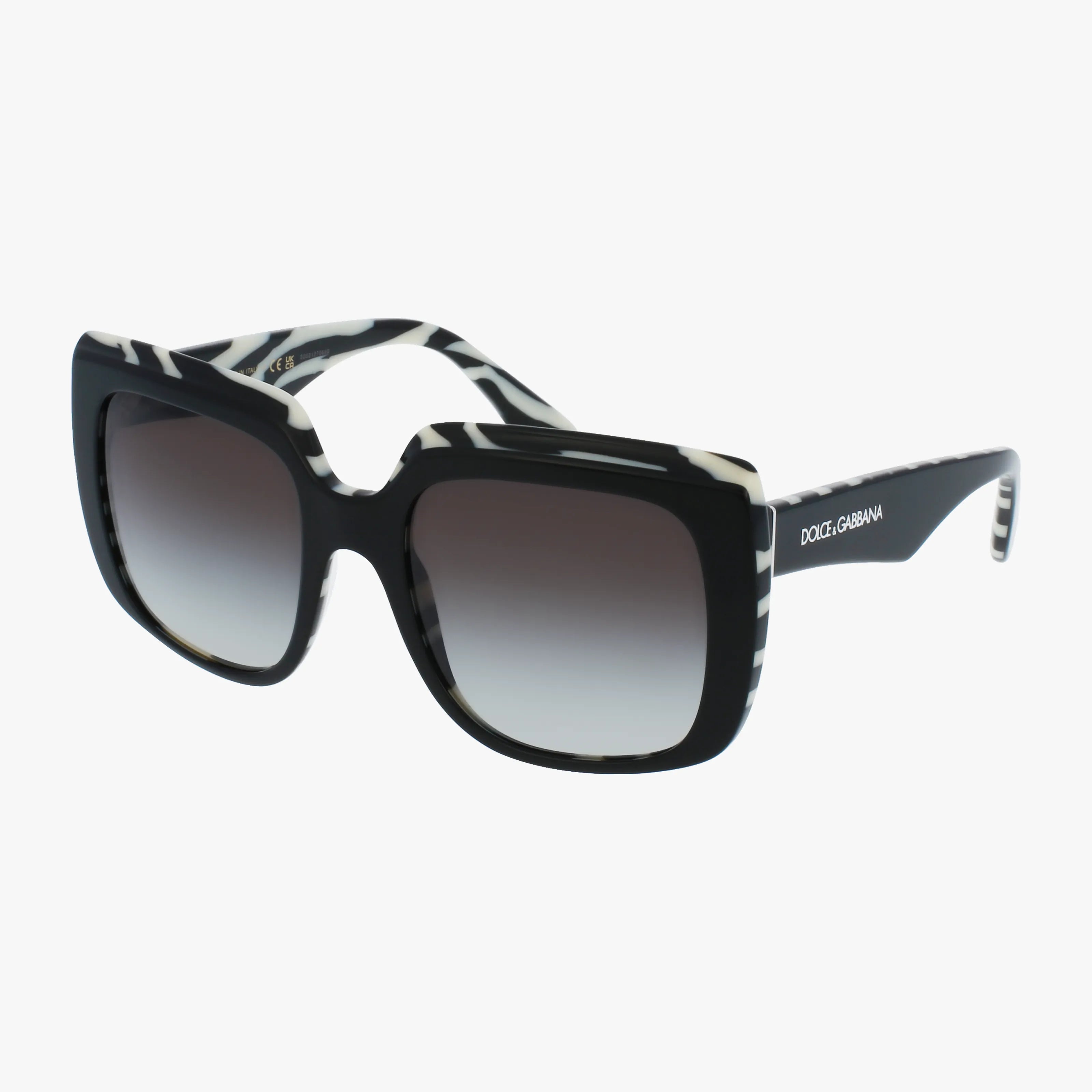 The DG4414 oversized square sunglasses feature black and white zebra-print frames, dark gradient UV-protective lenses, and the Dolce & Gabbana logo on the temple, shown against a plain white background.