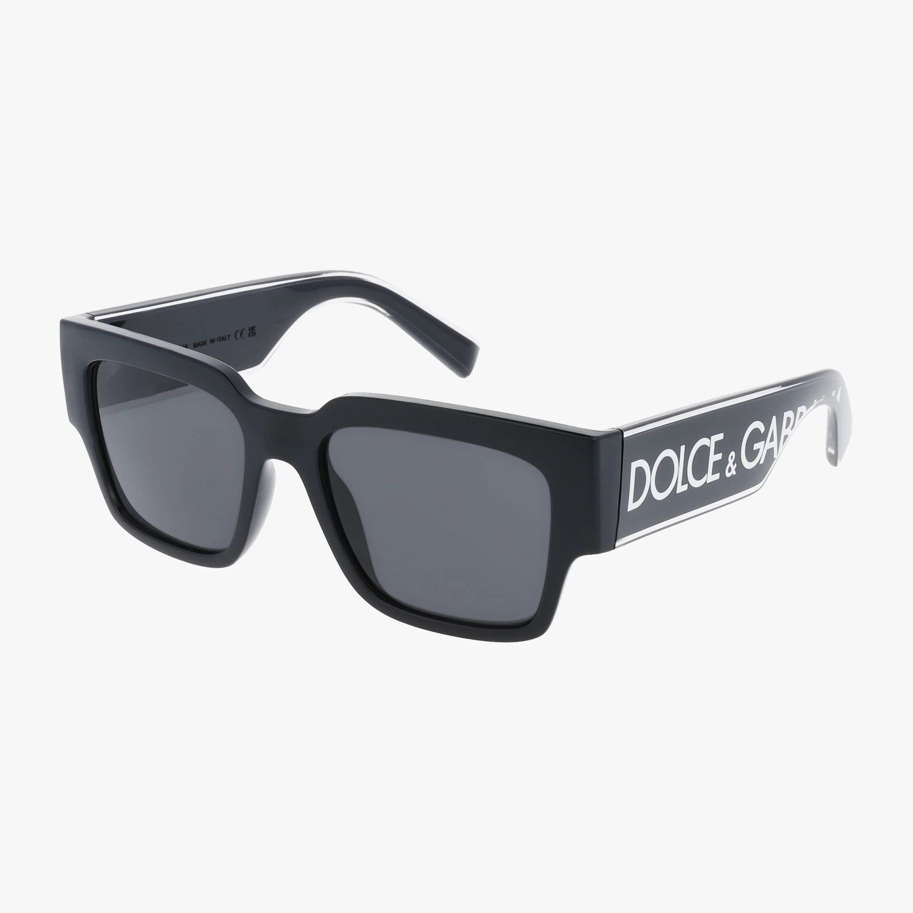 DG6184 black rectangular sunglasses with thick frames. Features the DOLCE & GABBANA logo in white on wide arms, dark-tinted lenses, and a partially open arm showing the inside.