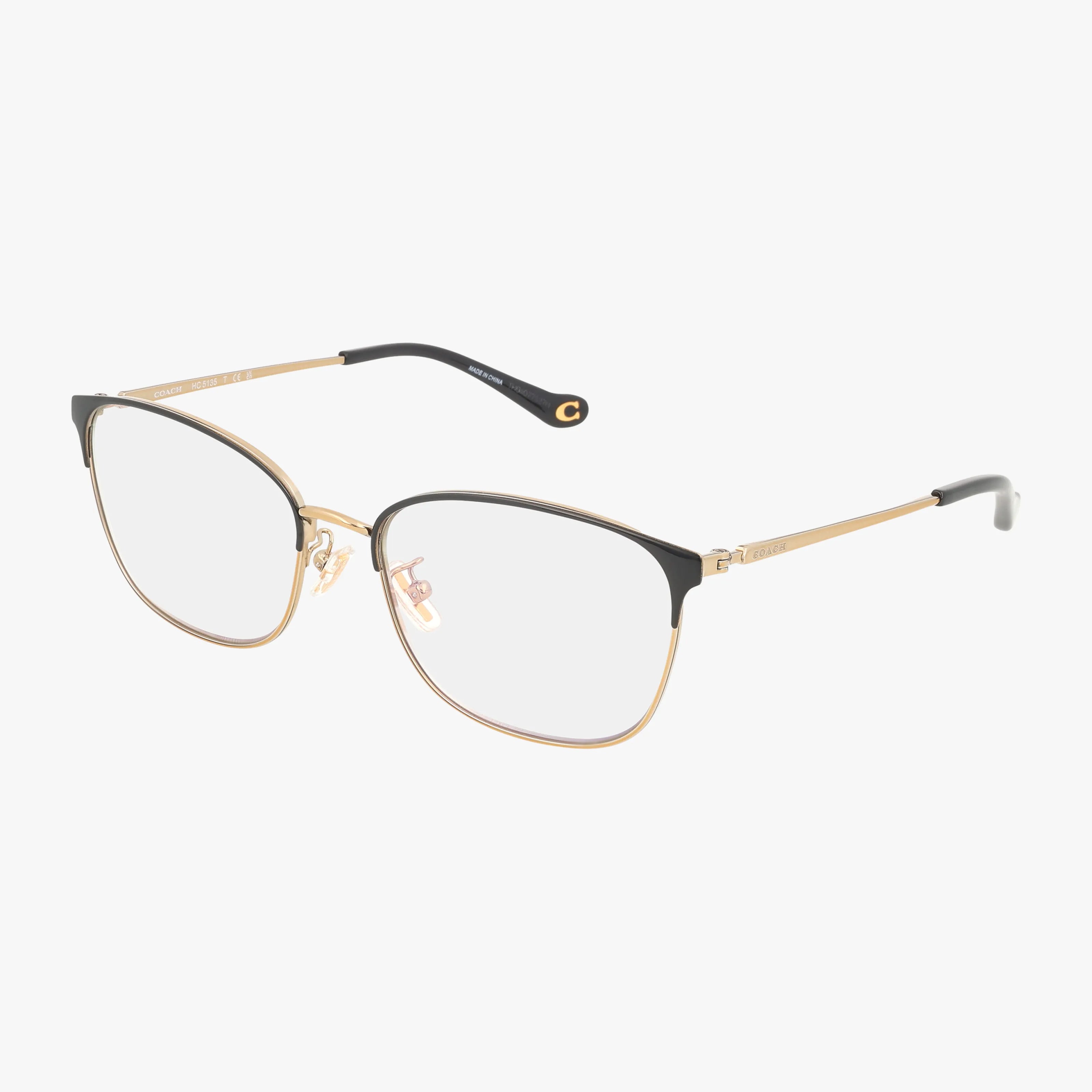 The HC5135 eyeglasses feature a lightweight gold and black thin metal frame, clear lenses, black rim detailing, and sleek arms with black tips—ideal for everyday wear and shown on a white background.