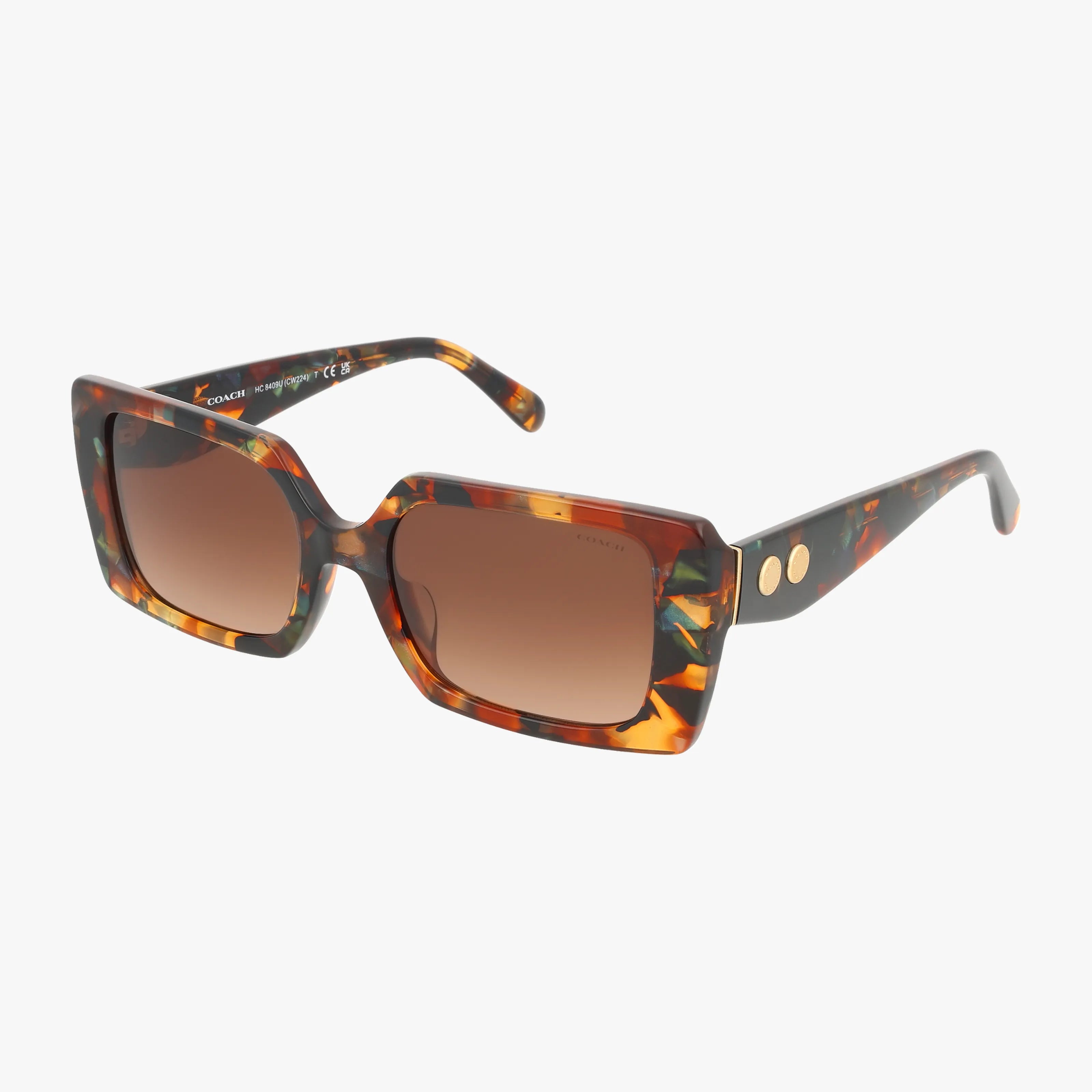 The HC8409U features oversized, square tortoiseshell sunglasses with brown gradient lenses and two gold circle accents on the temples. Lightweight and stylish, these frames offer practical protection, shown against a white background.
