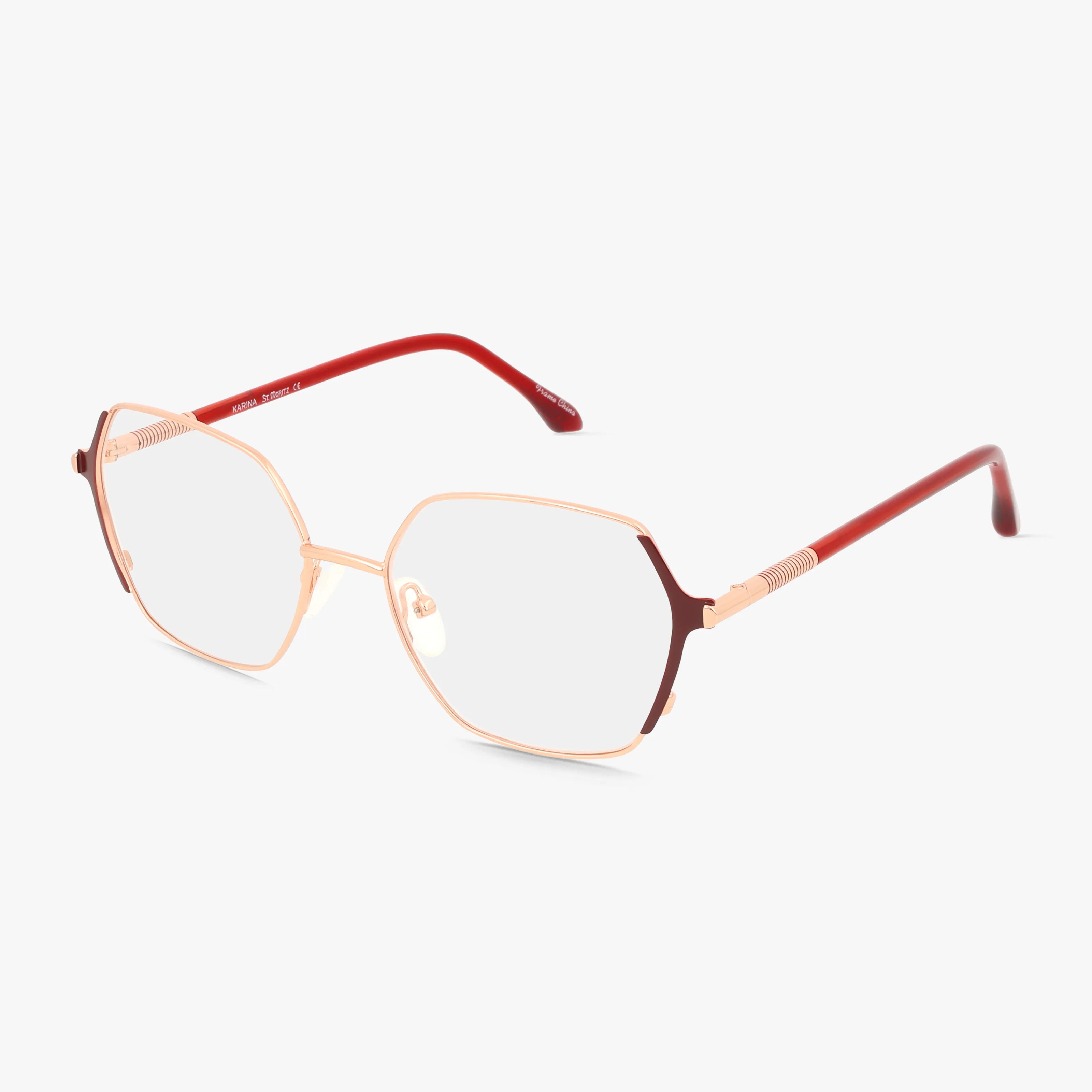 The KARINA eyeglasses feature a geometric rose gold minimalist frame with thin red arms, blending modern durability and style. Available with prescription lenses and displayed on a white background.