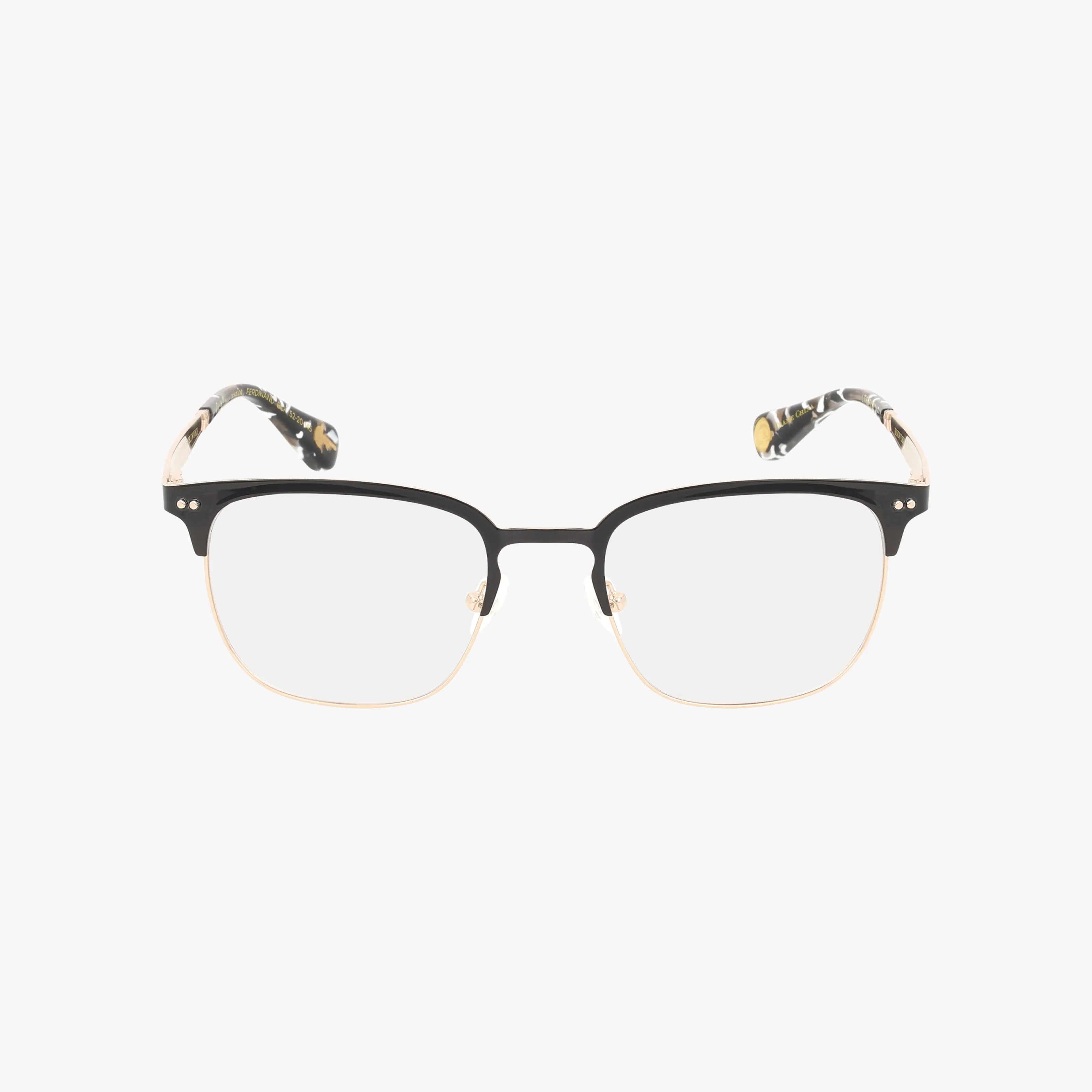 The FERDINAND eyeglasses feature a rectangular shape, resilient frame, black and gold rims, clear lenses, and patterned temple tips, presented against a plain white background.