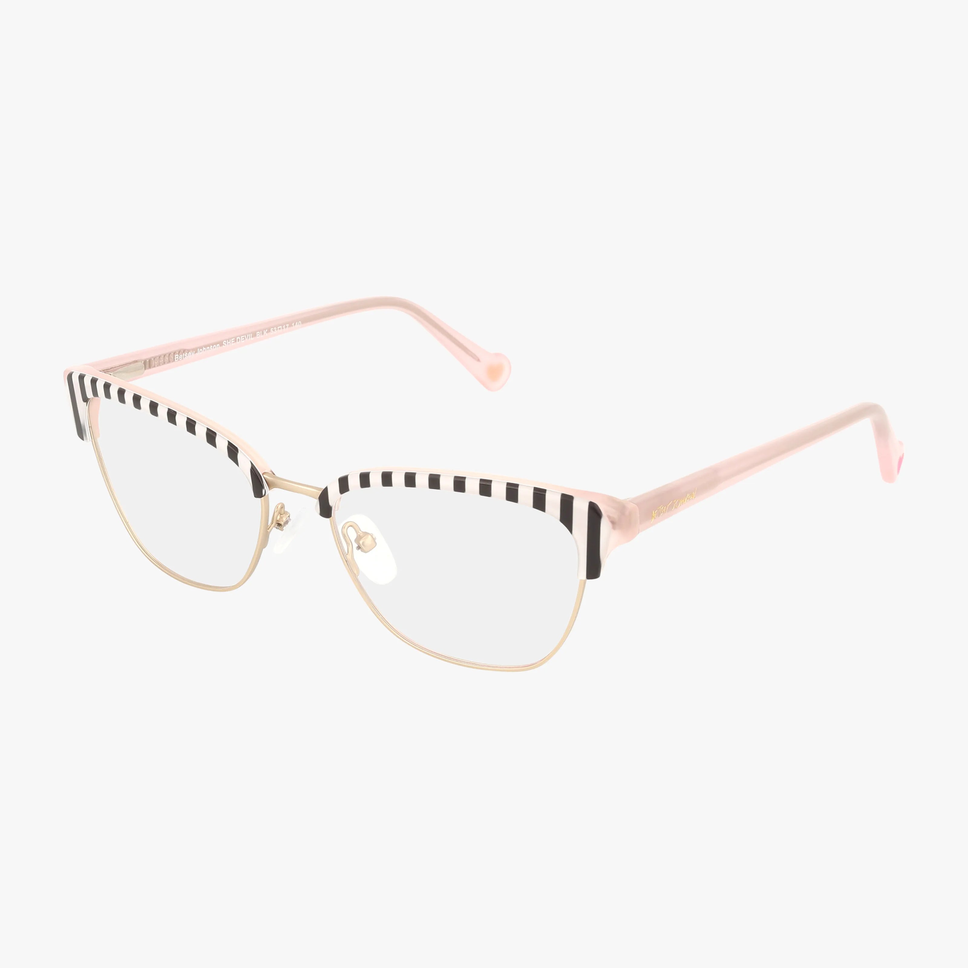 SHE DEVIL features flirty cat-eye gold metal frames, clear lenses, pink arms, and a playful black-and-white striped pattern along the top edge for a festive touch.