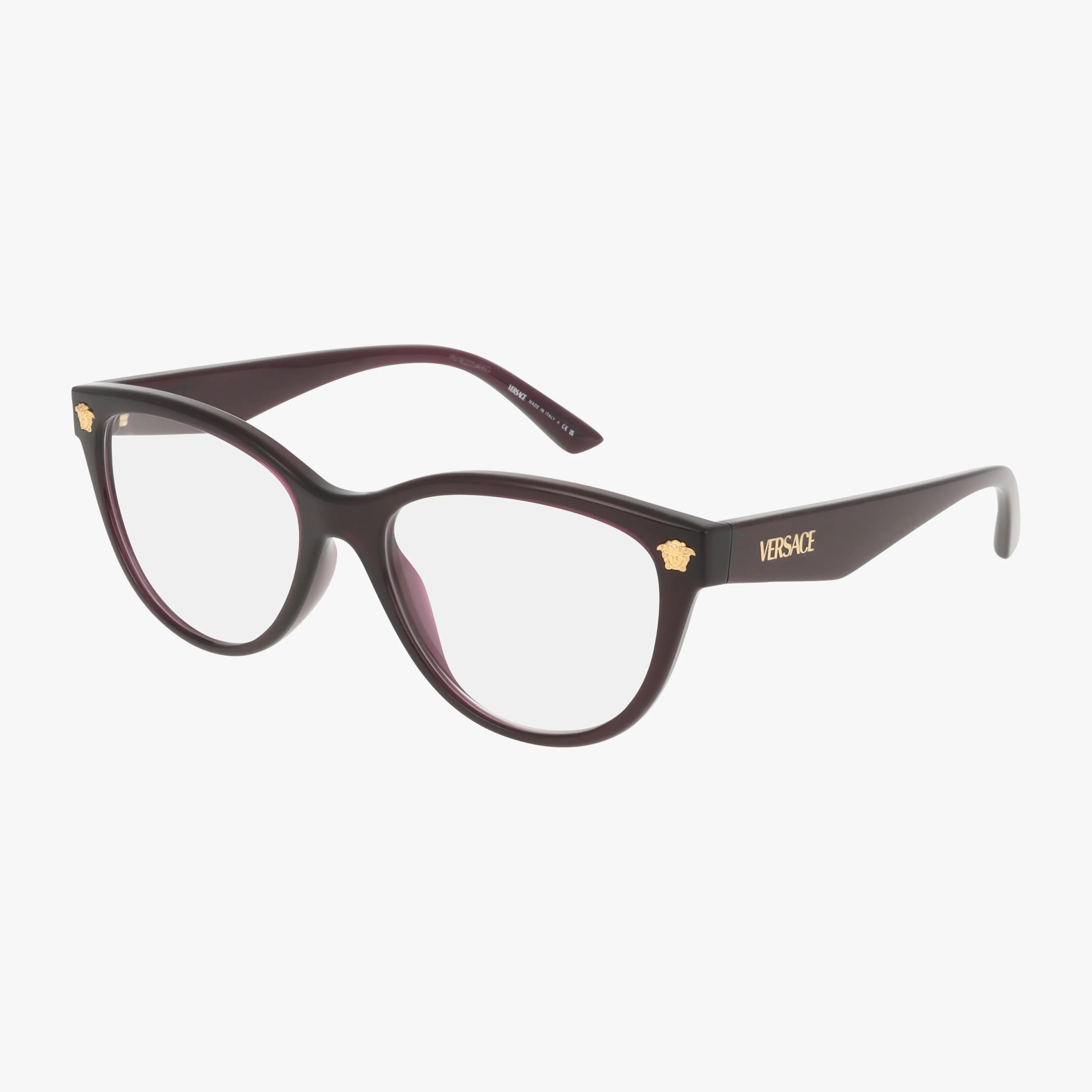 Angled view of the VE3365U Versace eyeglasses—modern dark purple cat-eye frame with gold Medusa logos at the corners and VERSACE branding on the temple. Durable eyewear shown against a white background.
