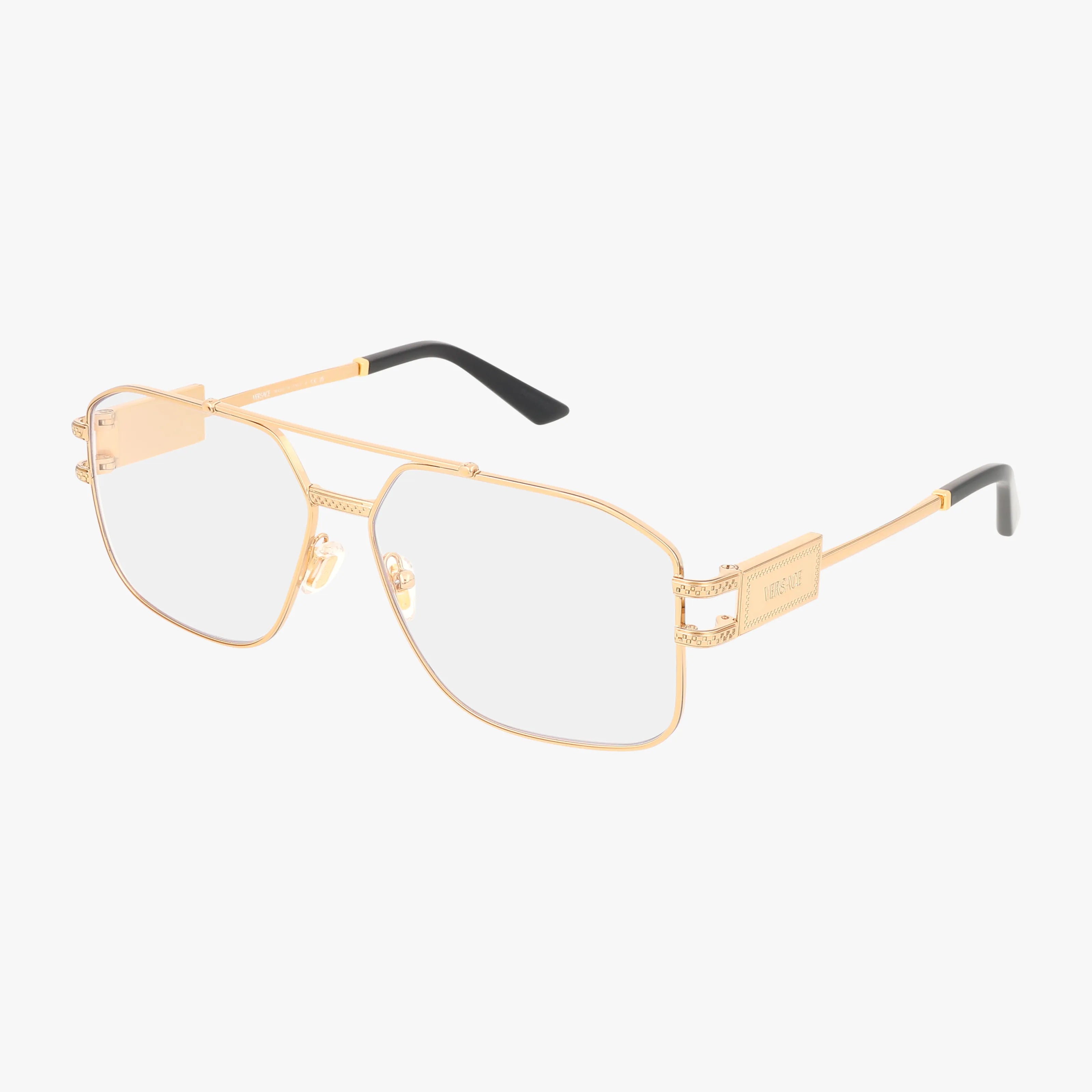 VE1302 gold aviator eyeglasses feature clear lenses, thin metal frames, black temple tips, and decorative arm details. This lightweight eyewear is shown against a white background.