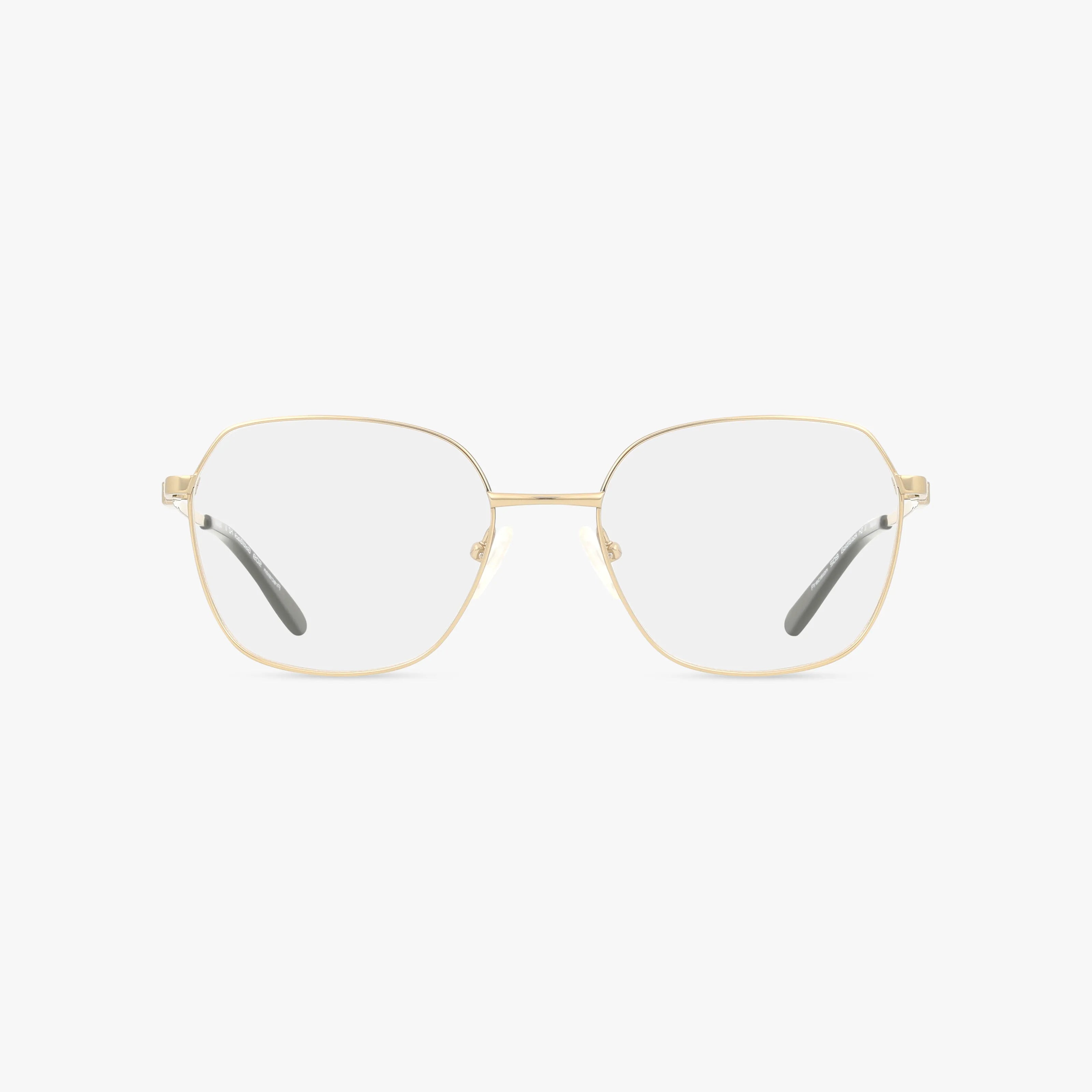 The 509 gold metal eyeglasses feature thin geometric hexagonal frames and clear lenses, showcased on a white background. Black-tipped temples add a bold touch, creating a look that embodies everyday excellence.