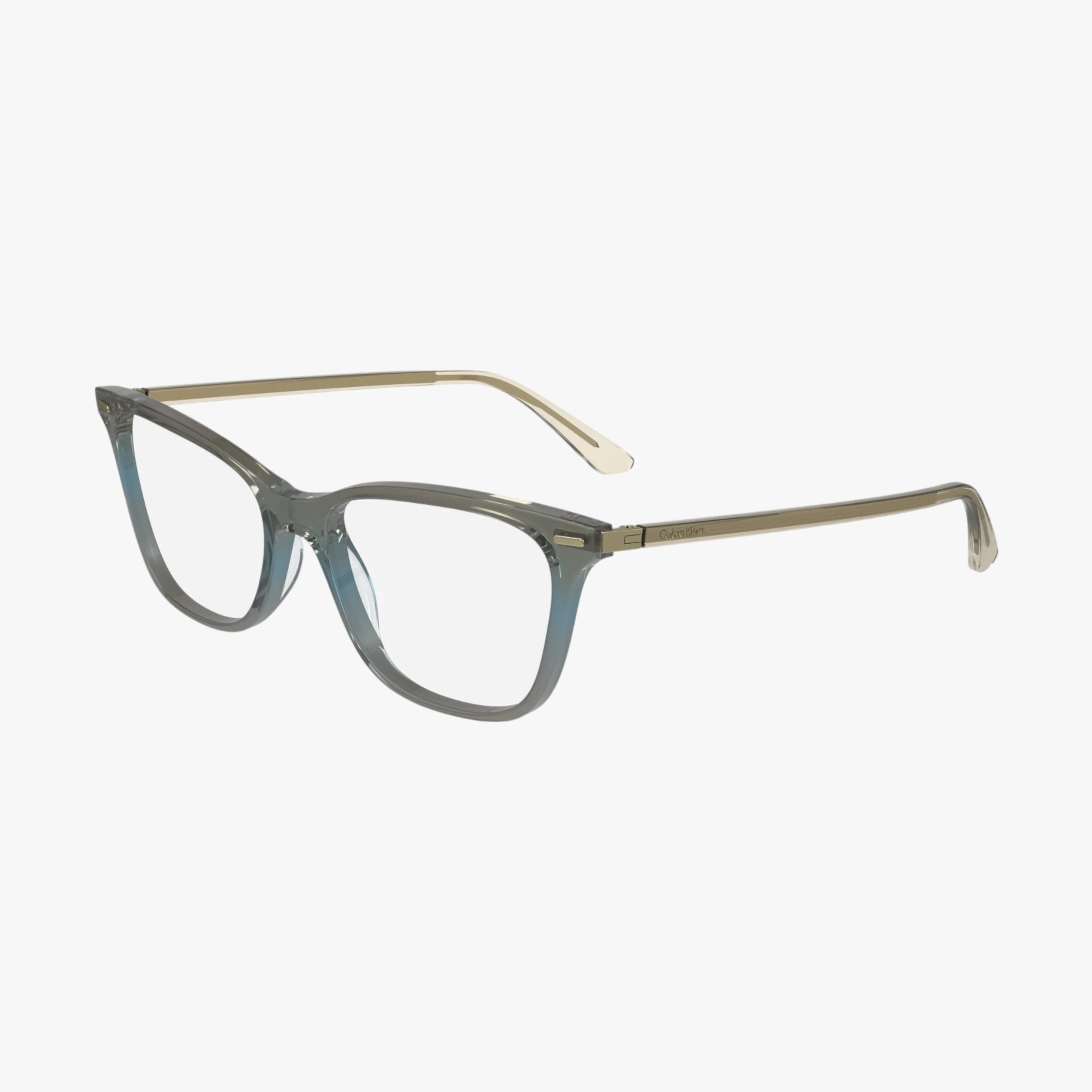 The CK23544 eyeglasses feature a translucent gray square Calvin Klein frame with slim, light gold metal arms, shown against a white background.