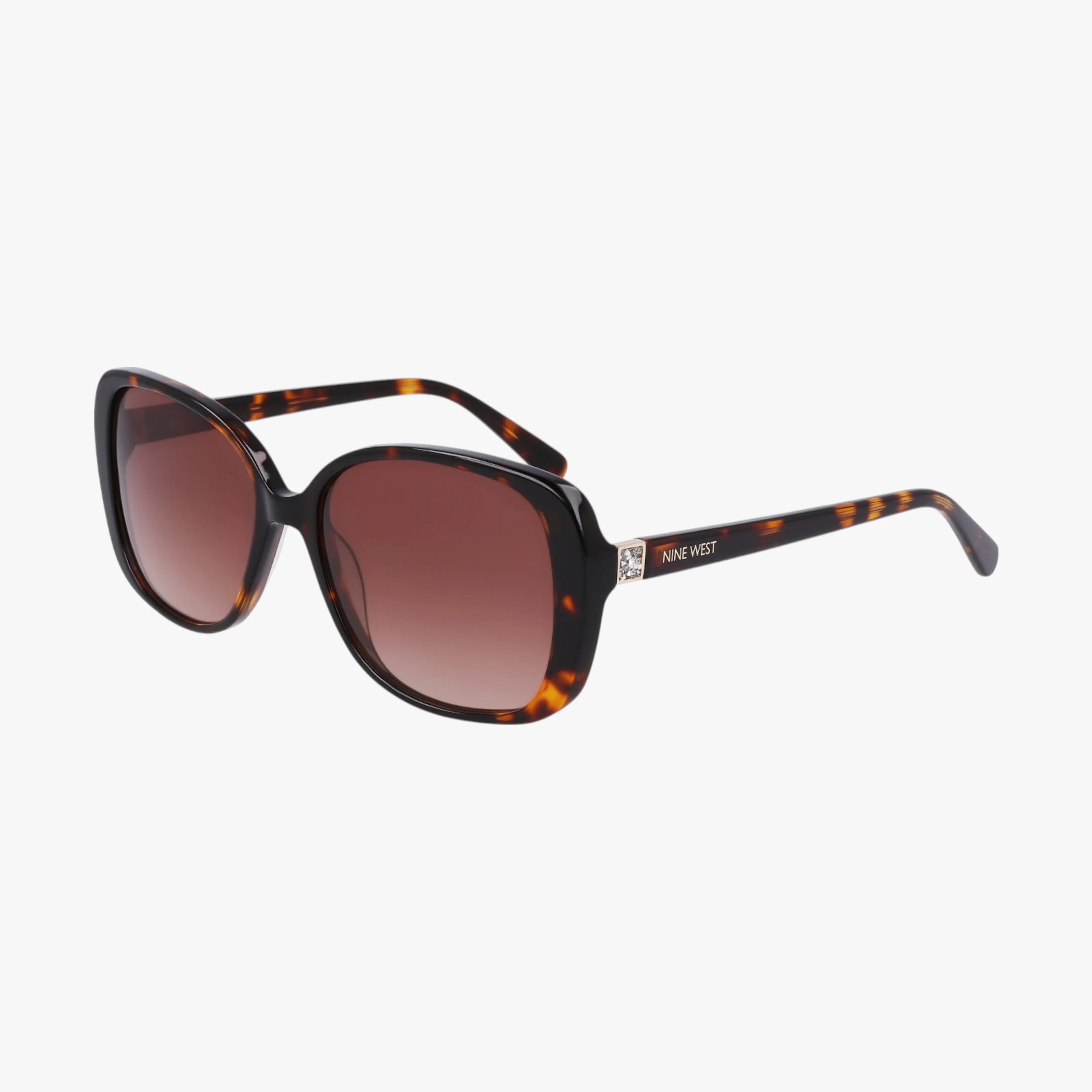 The NW657S sunglasses feature a stylish tortoiseshell frame, large rounded dark gradient lenses, and thick arms with the Nine West logo on the temple. These sturdy, versatile shades are showcased on a white background.