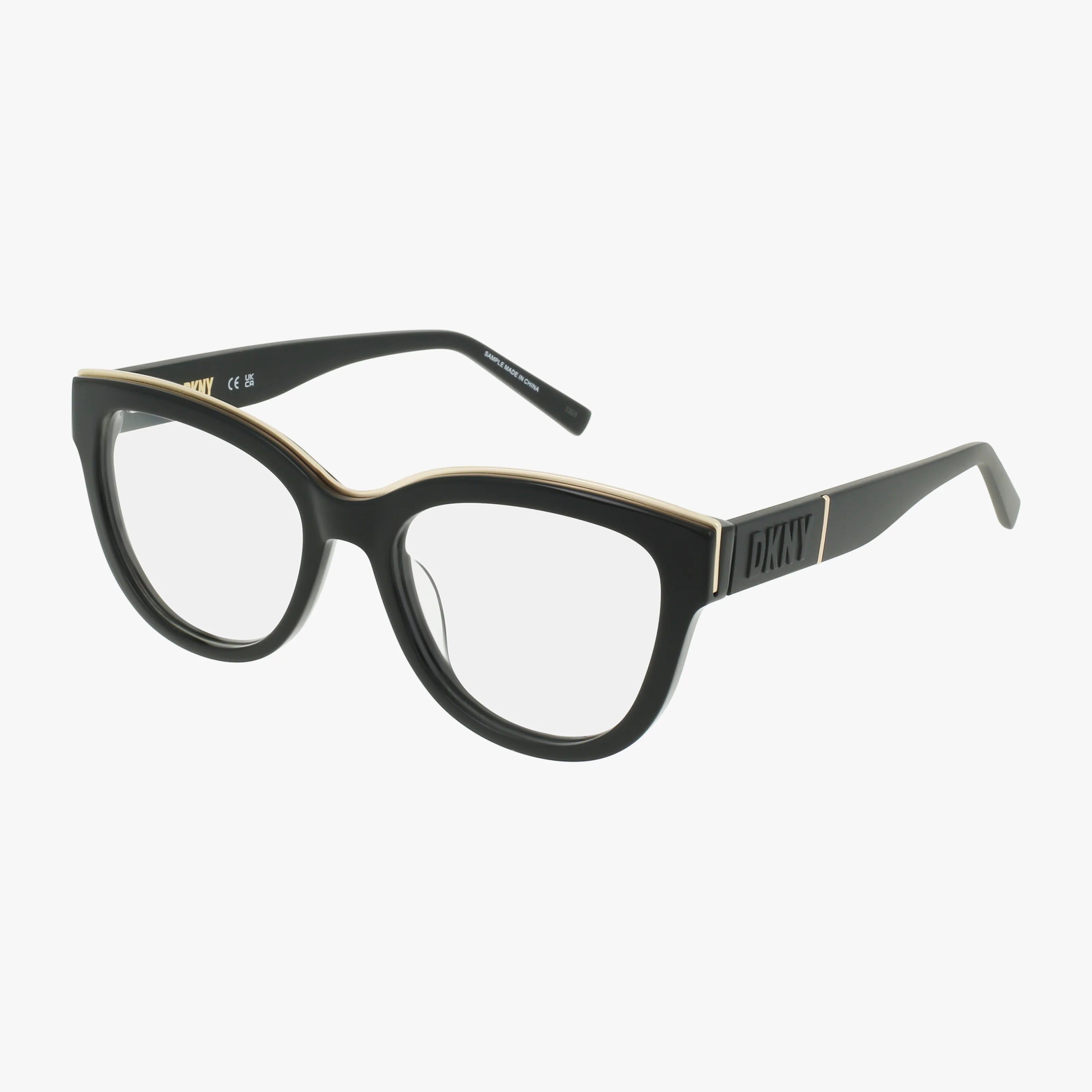 The DKNY DK5064 eyeglass frame features a black cat-eye shape, clear blue light lenses, and subtle gold detailing along the top, displayed on a plain white background.