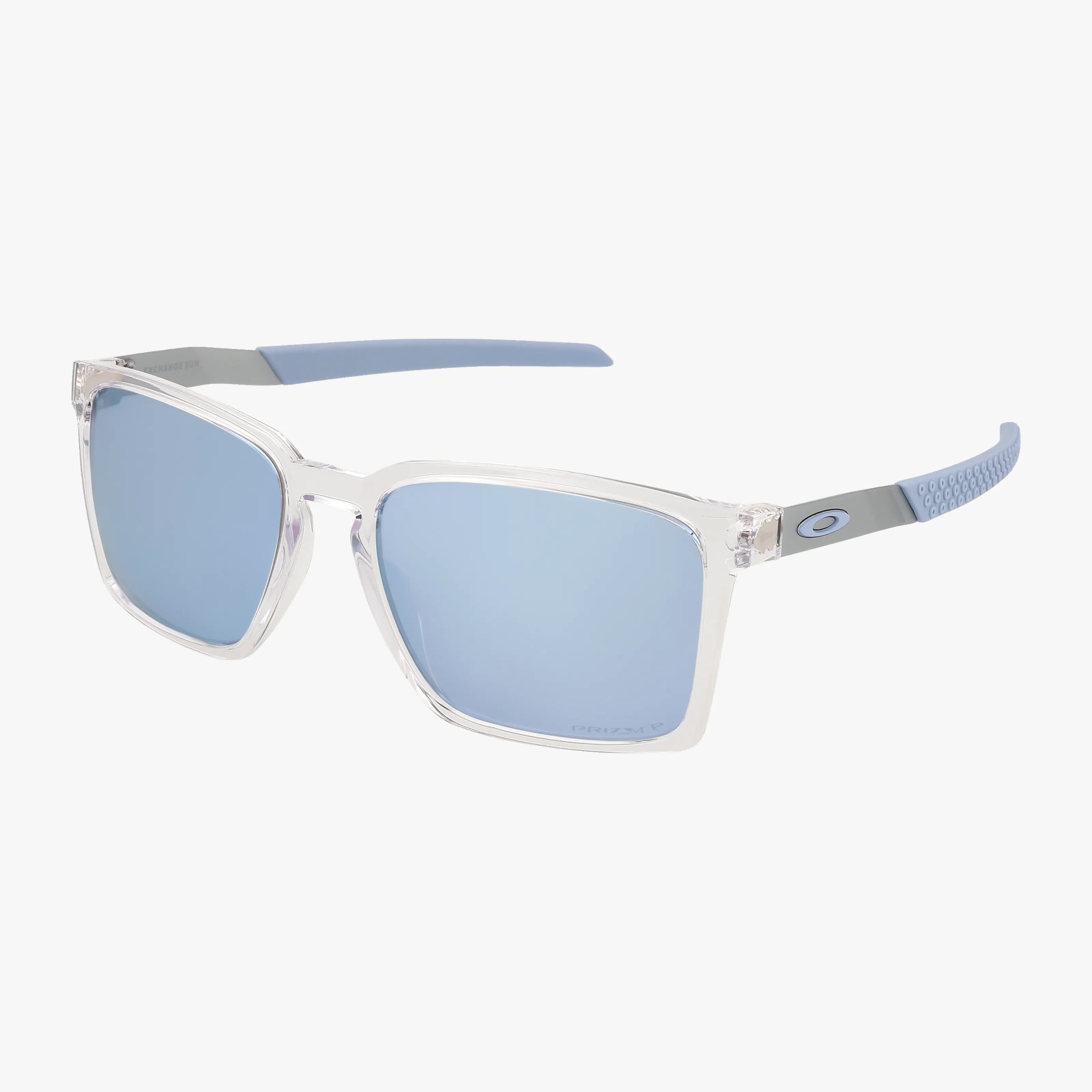 The OO9483 EXCHNAGE SUN sunglasses feature clear frames, light blue mirrored lenses, blue-gray arms with textured grip, and the Oakley logo—ideal for outdoor adventure. Shop these stylish sunglasses or browse more online today.