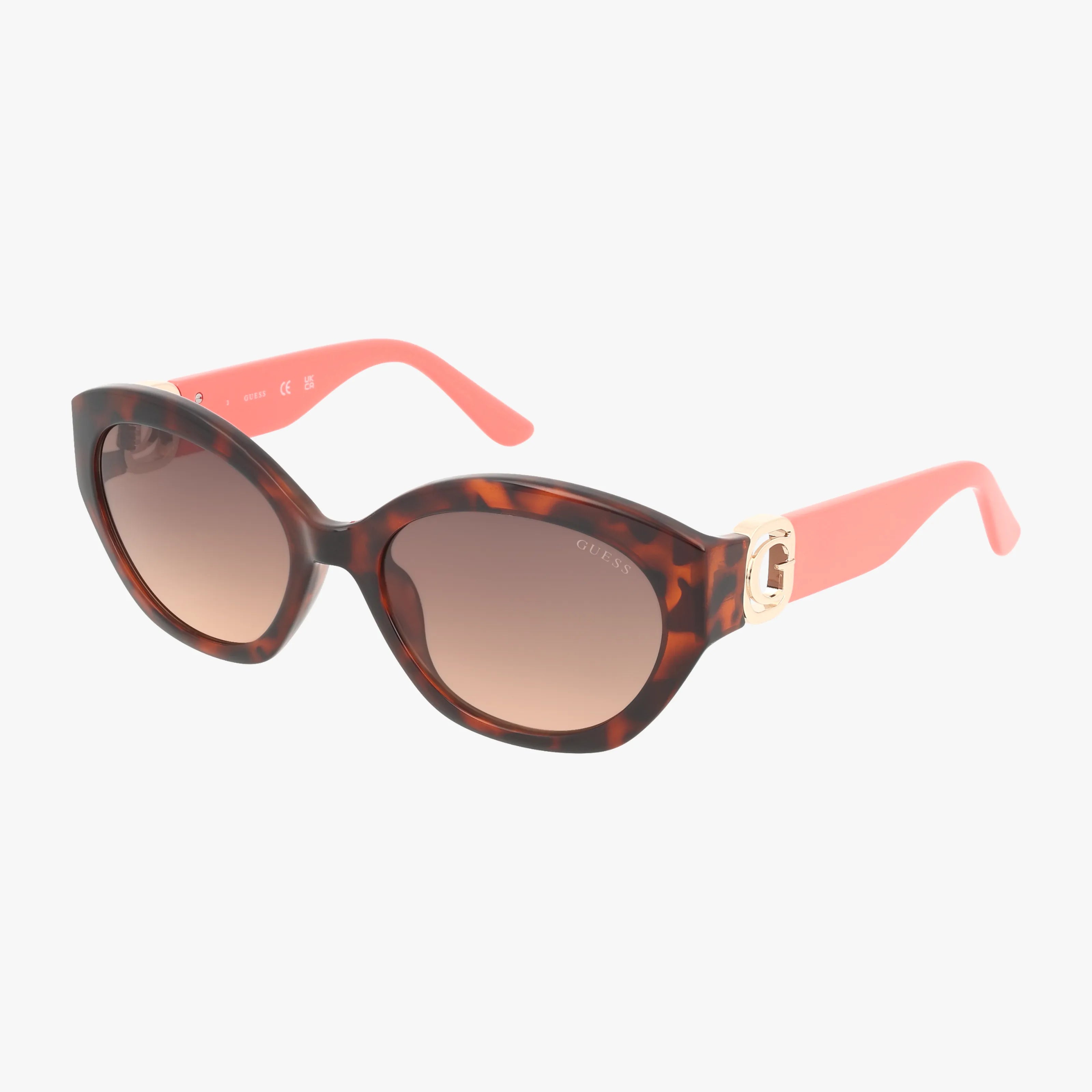 The GU00104/S sunglasses feature large round gradient lenses, tortoiseshell frames, coral pink arms, and gold-tone hinge details for chic sun protection on a white background.