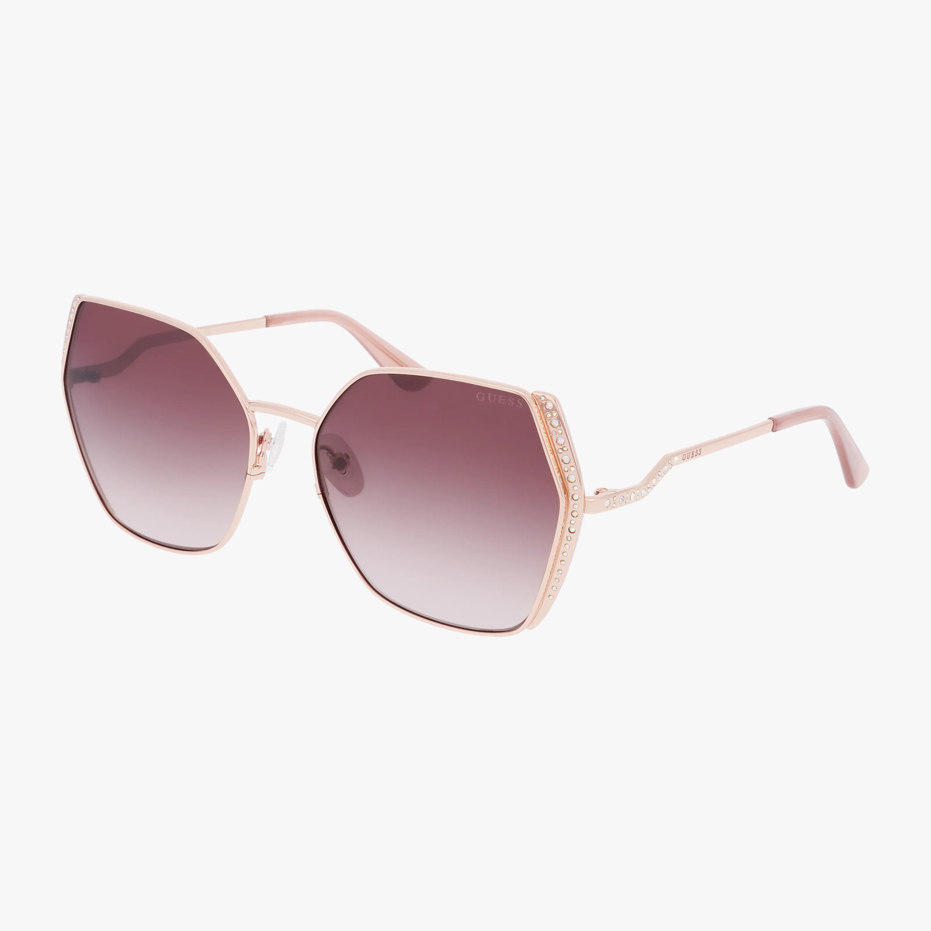 The GU7843S sunglasses feature a hexagonal oversized frame in rose gold metal, gradient purple lenses, and rhinestone-accented temples, shown on a white background.