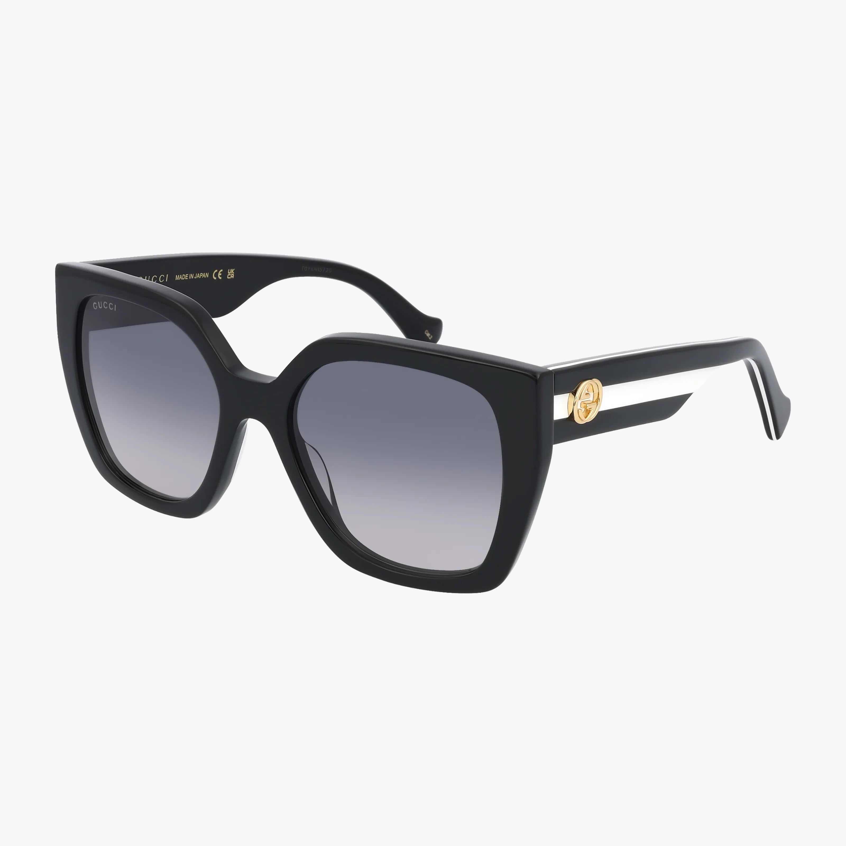 The Gucci GG1300S oversized square sunglasses feature black frames, gradient lenses, thick arms, and a gold Gucci logo on the side—perfect for a modern luxury look. Shown on a white background. Prescription lenses available.